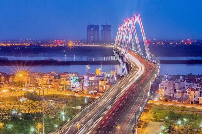 Hình ảnh Hà Nội: Cầu Nhật Tân ban đêm với vết sáng giao thông và ánh sáng thành phố ở xa
