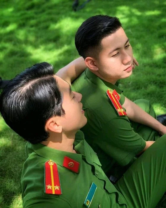 Hai chiến sĩ công an trẻ trao đổi trong khung cảnh ngoài trời