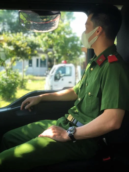 Nam chiến sĩ công an ngồi trong ô tô và nhìn ra ngoài cửa sổ