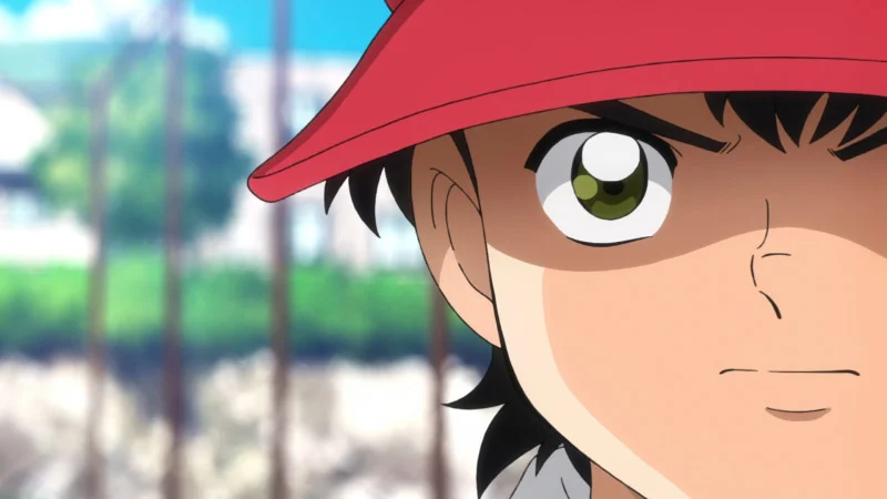 Ảnh em bé phong cách anime đội mũ đỏ, cận cảnh khuôn mặt với ánh mắt xanh nổi bật giữa khung cảnh ngoài trời