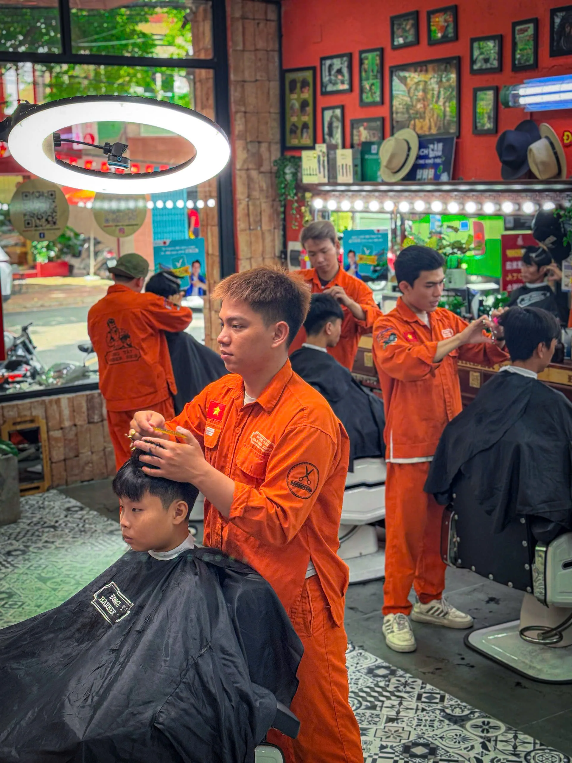 Thợ cắt tóc nam đang cắt cho khách hàng