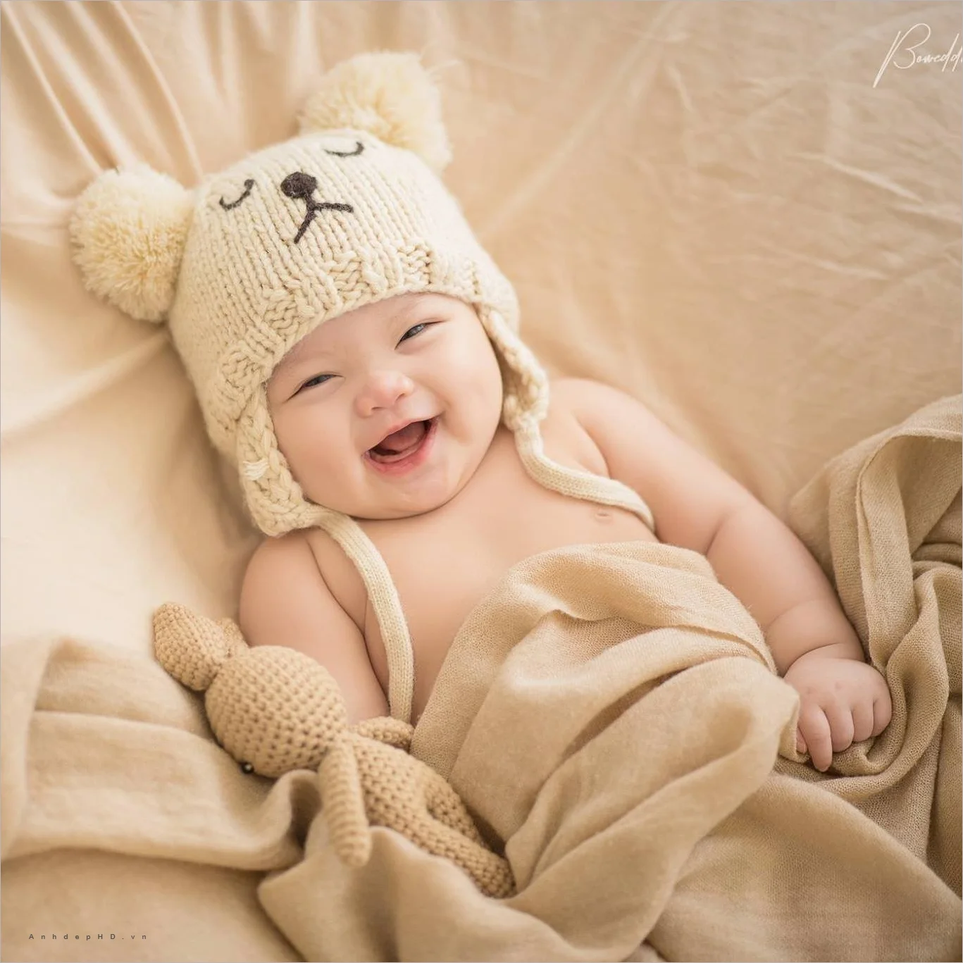 Ảnh em bé cười tươi rạng rỡ đội mũ len hình gấu dễ thương